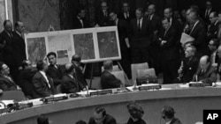 In this October 25, 1962 file photo, U.S. Ambassador Adlai Stevenson, far right, describes aerial photographs of launching sites for intermediate range missiles in Cuba during an emergency session of the United Nations Security Council at U.N. Headquarter