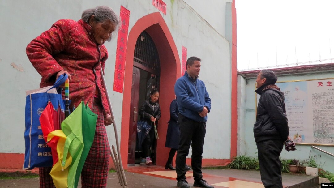 Pan Yinbao, a priest for Yingtan with the official church backed by the Beijing-controlled Catholic Patriotic Association, speaks with a faithful outside the church in Yingtan, Jiangxi province, China, March 25, 2018. 
