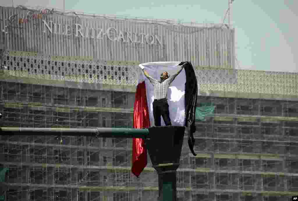 A protester holds a national flag as he chants slogans at a rally in Tahrir Square in Cairo. (AP) 