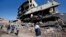 People walk past ruined buildings in Cizre, Turkey, early Wednesday, March 2, 2016.