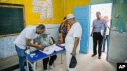 FILE — People queue to vote on a new constitution at a polling station in Tunis, July 25, 2022.