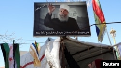 FILE - A sign depicting Syrian Druze leader Sheikh Hikmat al-Hajri is seen in Suwayda, Syria, Feb. 25, 2025.