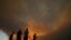 Residents of villages watch a fire in the Larnaca mountain region on July 3, 2021. 