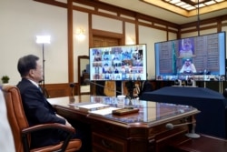 FILE - In this photo provided by South Korea Presidential Blue House via Yonhap News Agency, President Moon Jae-in attends G-20 virtual summit to discuss the coronavirus outbreak at the presidential Blue House in Seoul, March 26, 2020.