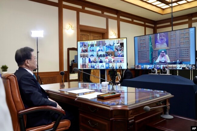 FILE - In this photo provided by South Korea Presidential Blue House via Yonhap News Agency, President Moon Jae-in attends G-20 virtual summit to discuss the coronavirus outbreak at the presidential Blue House in Seoul, March 26, 2020.