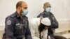 Amiram Ben Uliel, a Jewish extremist convicted of murder, reads while waiting during a sentencing hearing in Israel's central city of Lod on June 9, 2020.