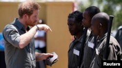 Britain's Prince Harry (L) chats to students at the Southern African Wildlife College, near the Orpen Gate of the Kruger National Park in the Limpopo province, South Africa, Dec. 2, 2015.