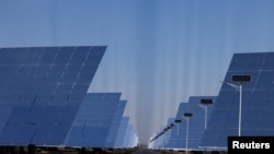 Fields of heliostat mirrors reflect sunlight at the site of Dunhuang Shouhang 100MW Tower Solar Thermal Power Generation Project, during an organized media tour to Dunhuang Photovoltaic Industrial Park, in Gansu province, China, Oct. 16, 2024. 