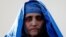 FILE - Sharbat Gula, the green-eyed 'Afghan Girl' whose 1985 photo in National Geographic became a symbol of her country's wars, arrives to meet with Afghanistan's President Ashraf Ghani in Kabul, Afghanistan, Nov. 9, 2016. 
