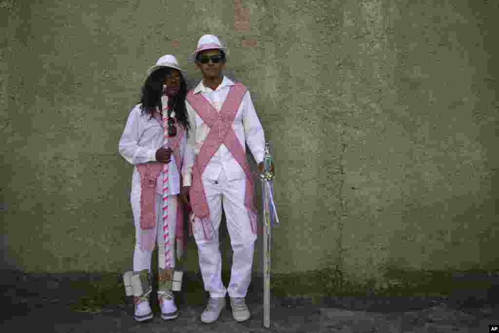 The captain, right, and a dancer with the Mozambique Sacred Heart of Mary dance group, during the annual Afro-Christian Congada celebration in Catalao, Goias state, Brazil, Oct. 9, 2016. The Congada represents an African royal court, with a king, queen, g