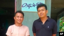 Aung San Oo, left, and Myo Myint Oo, pose for a picture in front of the office of the Tanintharyi Weekly Journal published by Dawei Watch media, in Dawei township in Tanintharyi region, Myanmar, in 2020.