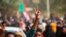 FILE - Pro-democracy protesters flash the victory sign as they take to the streets to condemn a takeover by military officials, in Khartoum, Sudan, Oct. 25, 2021. 
