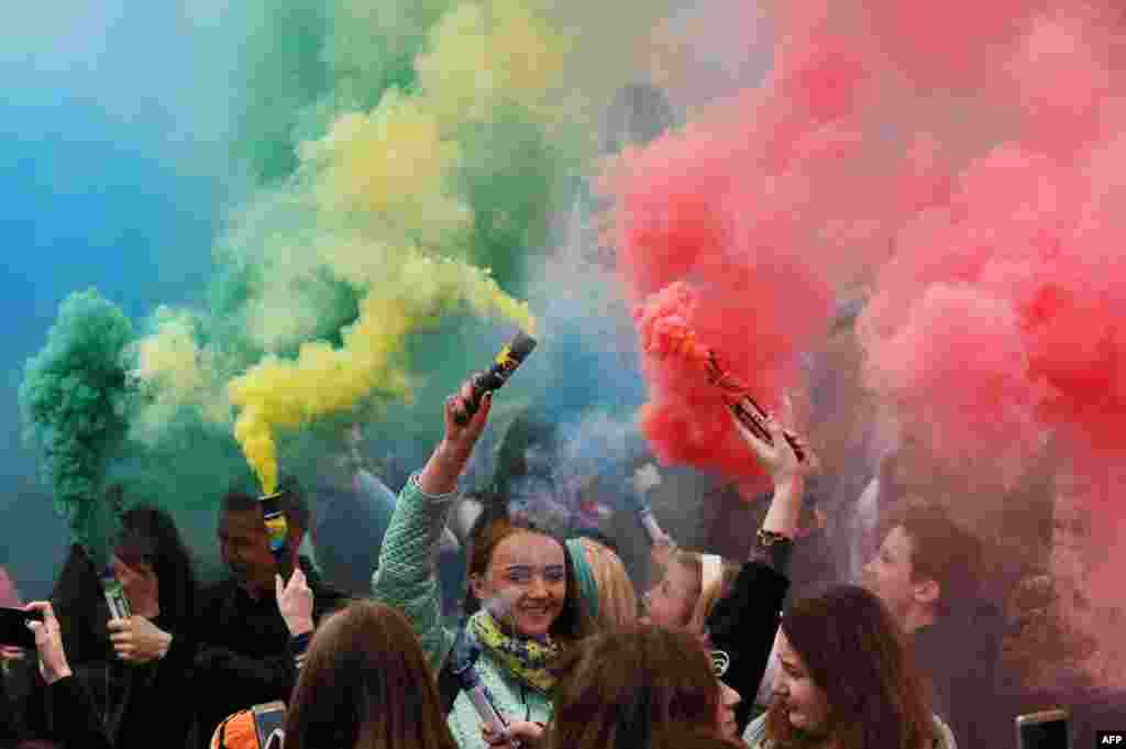 People holding colored smoke flares take part in a festive event in Minsk, Belarus.