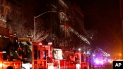 Petugas pemadam kebakaran berusaha memadamkan kebakaran di sebuah gedung apartement di Bronx, New York Kamis malam (28/12). 
