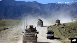 FILE - U.S. forces and Afghan commandos patrol in the Achin district of Jalalabad, east of Kabul, Afghanistan, April 2014.