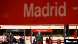 Commuters wearing protective face masks wait on a platform at Atocha train station during a partial lockdown amid the outbreak of the coronavirus disease (COVID-19), in Madrid, Spain, Oct. 5, 2020. 