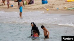 Une musulmane porte un burkini, un maillot de bain qui ne laisse que le visage, les mains et les pieds exposés, sur une plage à Marseille, France, 17 août 2016.