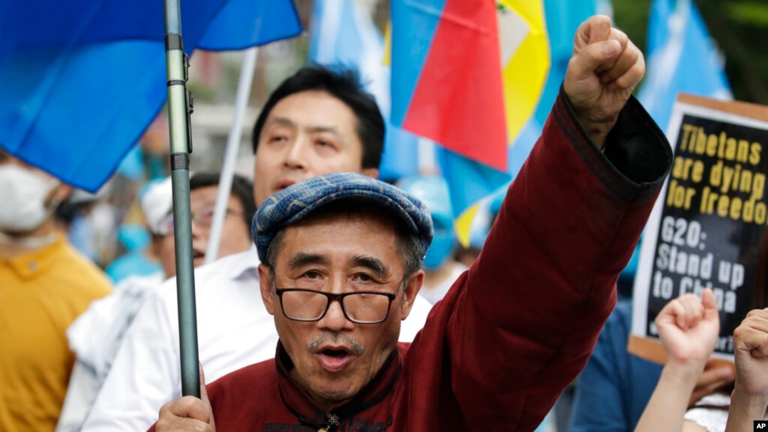 FILE - Temtselt Shobshuud of the Southern Mongolia Congress protests against the Chinese government, June 29, 2019, in Osaka, Japan. A young activist recently told U.S. lawmakers about Chinese Communist Party efforts to erase Mongolian heritage and culture.