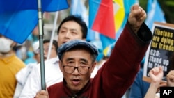 FILE - Temtselt Shobshuud of the Southern Mongolia Congress protests against the Chinese government, June 29, 2019, in Osaka, Japan. A young activist recently told U.S. lawmakers about Chinese Communist Party efforts to erase Mongolian heritage and culture.