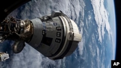 In this photo provided by NASA, Boeing's Starliner spacecraft is docked to the Harmony module of the International Space Station on July 3, 2024, seen from a window on the SpaceX Dragon Endeavour spacecraft docked to an adjacent port. (NASA via AP)