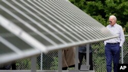 Former vice president and Democratic presidential candidate Joe Biden looks at an array of solar panels during a tour at the Plymouth Area Renewable Energy Initiative in Plymouth, N.H., June 4, 2019.