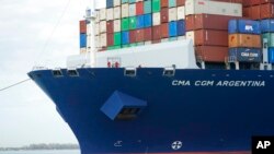 FILE - Crew members stand on the bow as the CMA CGM Argentina arrives at PortMiami, the largest container ship to call at a Florida port, April 6, 2021.