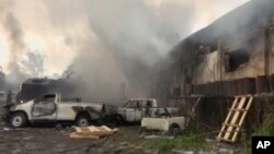 In this image from video, smoke envelopes a building as emergency services attend an early-morning fire in Congo's capital Kinshasa, Dec. 13, 2018, which is reported to have destroyed thousands of voting machines just 10-days before the upcoming president