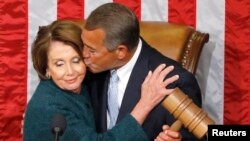 Ketua DPR John Boehner dari Partai Republik memberikan ciuman di pipi ketua Fraksi Minoritas Nancy Pelosi dari Partai Demokrat ketika secara simbolis menerima palu ketua sidang di Gedung DPR, Washington DC (6/1/2015). 