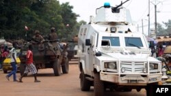 Police officers from the United Nations Multidimensional Integrated Stabilization Mission in the Central African Republic (MINUSCA) in an armored vehicle patrol a market in Bangui's Combattant district, Sept. 14, 2015.