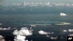 FILE - This aerial photo taken through a glass window of a military plane shows China's alleged on-going reclamation of Mischief Reef in the Spratly Islands in the South China Sea.