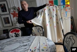 Designer Jean-Charles de Castelbajac displays a liturgical vestment for priests and to be worn at the December reopening of Paris' Notre-Dame Cathedral, Nov. 20, 2024.