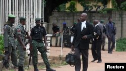 Des avocats passent devant des policiers qui montent la garde devant un tribunal qui doit statuer sur la demande de libération sous caution du dirigeant chiite Zakzaky à Kaduna, au Nigeria, le 29 juillet 2019.