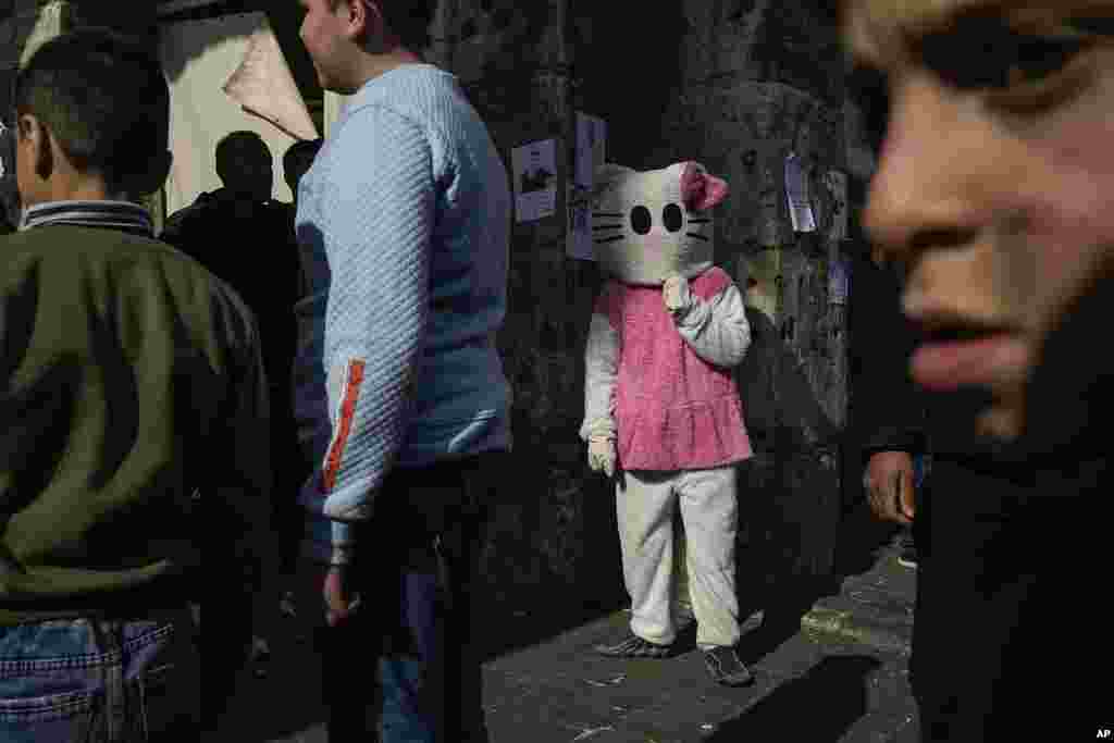 A person disguised as a cat stands in the street near the Umayyad Mosque ahead of Friday prayers in Damascus, Syria.