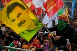A youth holds a flag with the image of Abdullah Ocalan, the jailed leader of the rebel Kurdistan Workers' Party, or PKK, during the Newroz celebrations, marking the start of spring, in Istanbul, March 21, 2018.