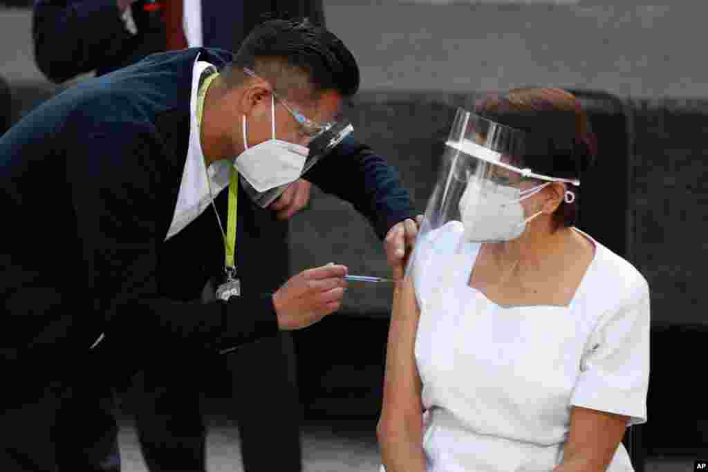 멕시코 멕시코시티의 제너럴병원에서 의료 종사자 마리아 라미레스 씨가 화이자-바이오엔테크 신종 코로바아리서 백신을 맞고 있다. 