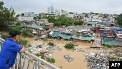 A man standing on Long Bien Bridge looks down at houses partially submerged in floodwaters in Hanoi on Sept. 10, 2024, after Typhoon Yagi hit Vietnam.