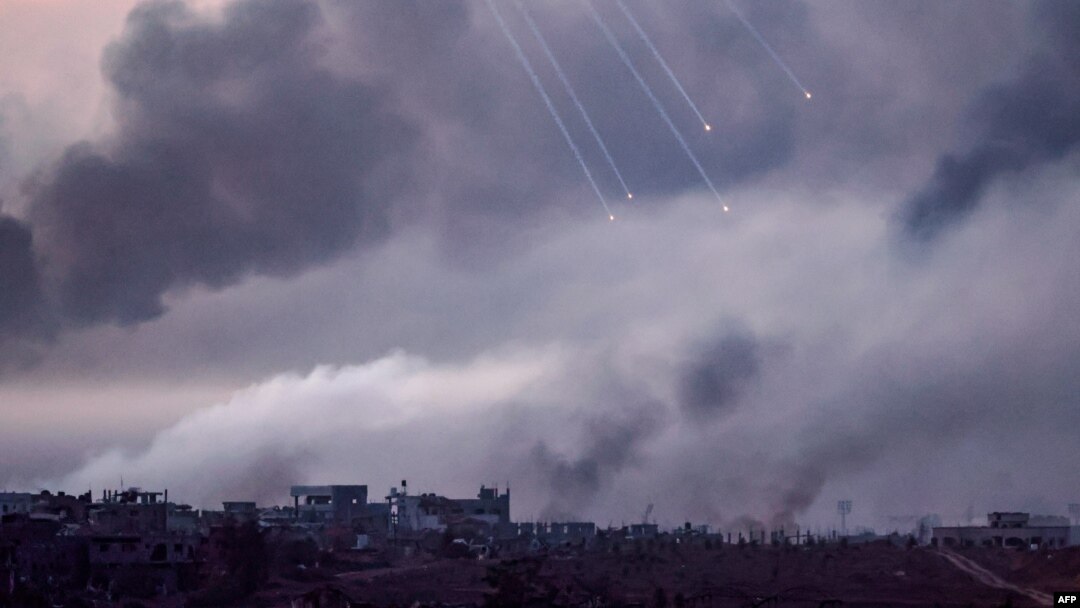 Gambar yang diambil dari perbatasan Israel dengan Jalur Gaza ini menunjukkan asap hitam membubung saat suar dijatuhkan di atas gedung-gedung di bagian utara daerah kantong Palestina selama serangan Israel, 22 November 2023. (JACK GUEZ / AFP)