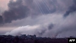 Gambar yang diambil dari perbatasan Israel dengan Jalur Gaza ini menunjukkan asap hitam membubung saat suar dijatuhkan di atas gedung-gedung di bagian utara daerah kantong Palestina selama serangan Israel, 22 November 2023. (JACK GUEZ / AFP)