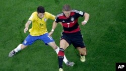 Oscar dari Brazil (kiri) dan Bastian Schweinsteiger (kanan) berebut bola dalam pertandingan semifinal, Selasa (7/8).