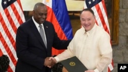 U.S. Defense Secretary Lloyd Austin, left, and Philippine Secretary of National Defense Gilberto Teodoro shake hands after signing a military intelligence-sharing deal at Camp Aguinaldo military headquarters in Quezon City, Philippines, Nov. 18, 2024.