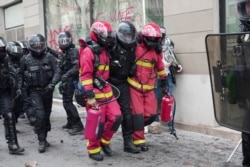 Firefighters carry police officer away from clashes during the traditional May Day protests, amid the coronavirus disease (COVID-19) outbreak in Paris, France, May 1, 2021.
