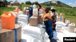 FILE: Villagers collect food aid distributed by the World Food Program (WFP) following a prolonged drought in rural Mudzi district, Zimbabwe, February 20, 2020. Picture taken February 20, 2020. REUTERS/Philimon Bulawayo