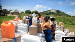 Warga desa mengambil bantuan makanan yang didistribusikan oleh World Food Program menyusul kekeringan di distrik Mudzi, Zimbawe, 20 Februari 2020. (Foto: Reuters)