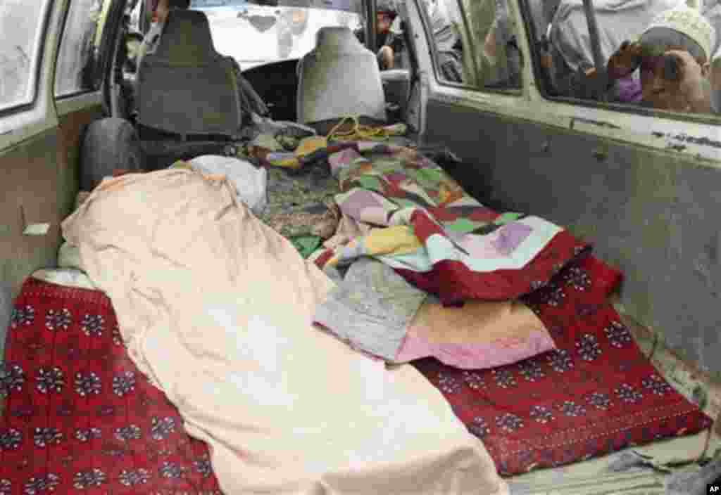 An Afghan boy peeks into a bus carrying the body of a person who was allegedly killed by a U.S. service member in Panjwai, Kandahar province south of Kabul, Afghanistan, Sunday, March 11, 2012. Afghan President Hamid Karzai says a U.S. service member has
