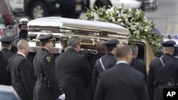 2012年2月，美国著名歌星惠特尼.休斯顿的葬礼在新泽西举行，数百万人在网上观看。图为她的灵柩被抬上灵车