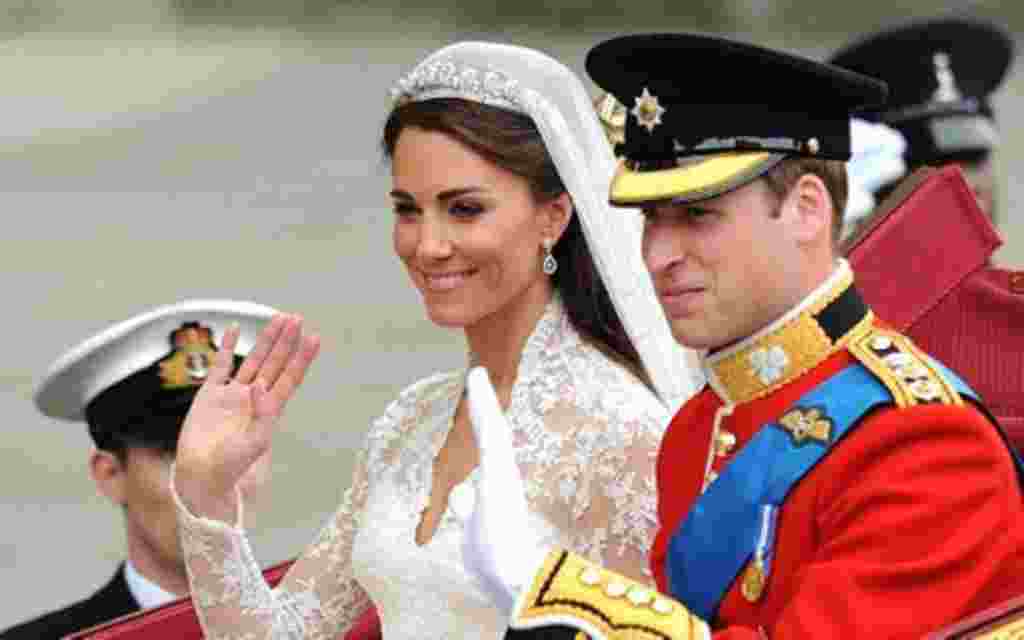 Britain's Prince William and his wife Kate, Duchess of Cambridge, wave as they travel in the 1902 State Landau carriage along the Processional Route to Buckingham Palace, in London, on April 29, 2011.