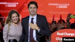 Pemimpin partai Liberal Kanada, Justin Trudeau didampingi istrinya, Sophie Gregoire, memberikan pidato kemenangan di Montreal, Quebec, Senin (19/10).