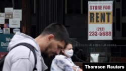 Personas caminan frente a una tienda cerrada en Nueva York, EE.UU. [Archivo]