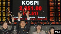 Para pegawai Bursa Saham Korea menyambut gembira kenaikan tertinggi indeks saham KOSPI pada penutupan pasar saham, 30 Desember 2010.