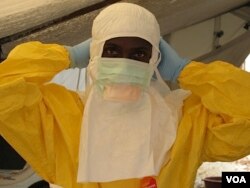Health care workers' protective gear can look frightening. Here, a worker prepares to care for Ebola patients at the Doctors Without Borders treatment unit at Donka hospital in Conakry, Guinea.